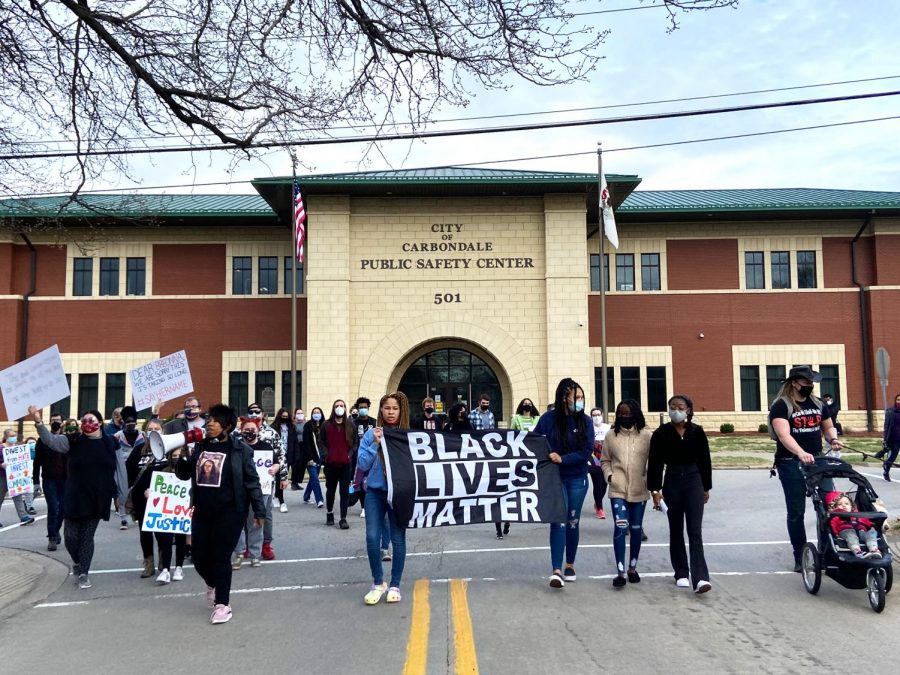 Protestors march on East College St. through downtown back to the Carbondale Pavilion on Saturday, March 13, 2021 in Carbondale Ill. 
