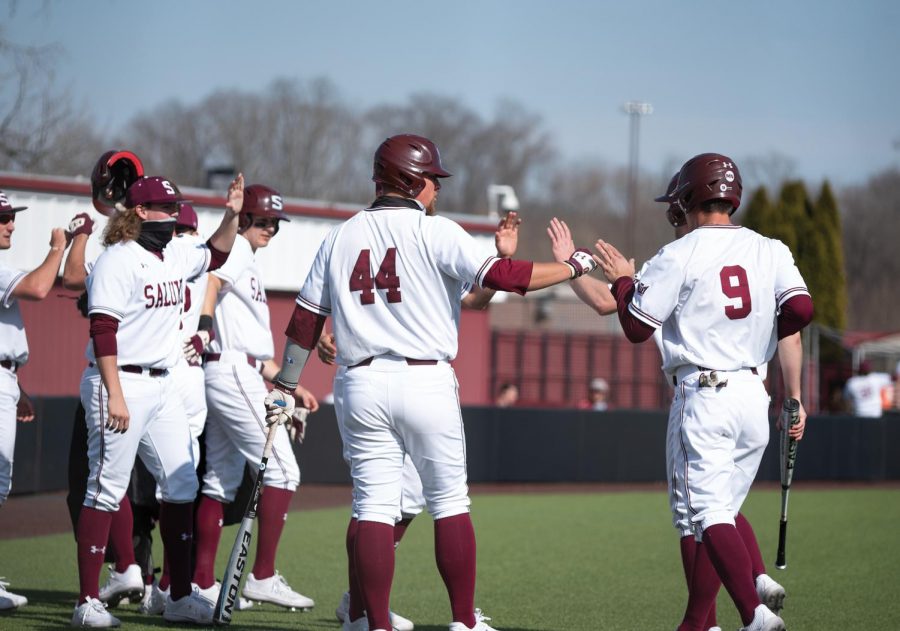 Philip Archer (44) and Nick Neville (9) celebrate after making four runs against University of Tennessee at Martin on Sunday, Mar. 7, 2021 at Itchy Jones Stadium in Carbondale Ill.