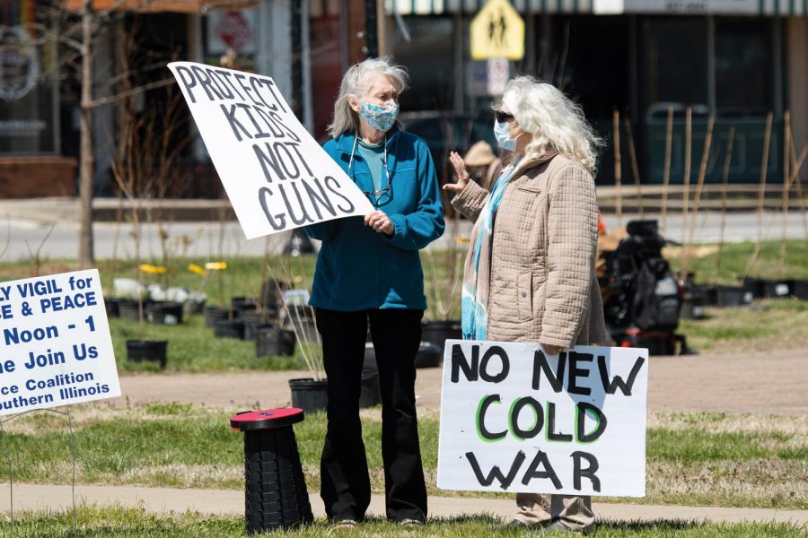 Protestors hold their signs during the Peace Coalition of Southern Illinois’ community rally for peace and justice on Saturday, April 3, 2021 on the corner of Main Street in Carbondale, Ill.