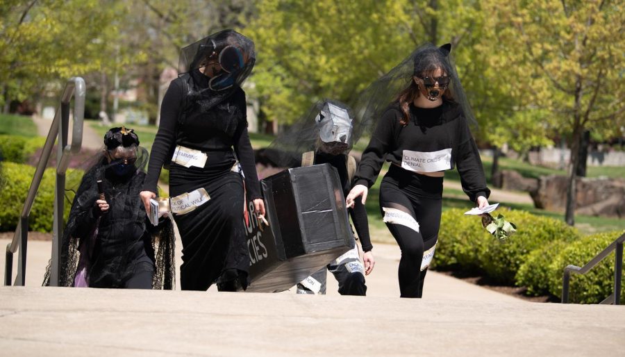 SIU students towards the SIU Morris Library in a funeral casket walking honor of countless species of animals that have gone extinct on Thursday, April 22, 2021.