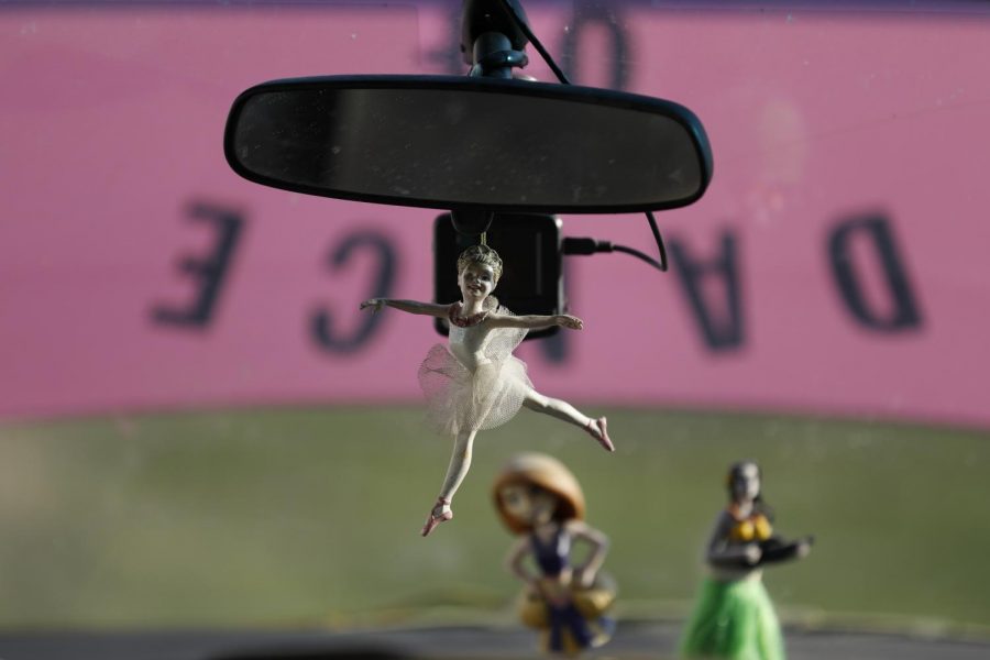 A figurine of a ballet dancer hangs from the rear-view mirror of Susan Stone’s pink van.