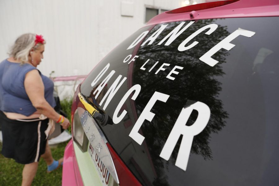 Susan Stone, also known as the Dance of Life Dancer, walks past her pink van outside of her trailer in Lenzburg, Ill. Stone has been dancing in local parks, concerts and festivals for 21 years and credits her ‘Dance of Life’ passion for giving her hope, “It refreshes me with energy, refreshes me with life and hope!” Susan said.