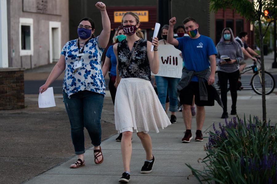 Activists participate in the vigil during the march on the stand with survivors of sexual violence on Friday, April 30, 2021, in Carbondale, Ill. The event was organized with the joint effort of staffs of The Women’s Center and lasted for 2 hours starting at 7 p.m.