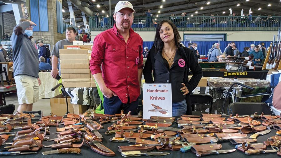 Brandon Kuschnereit and Hollie Andress stand behind their table of hand-crafted knives at the Wanenmachers Arms Show April 10, 2021 in Tulsa, Okla. Many booths participated in the show with products ranging from a small knife to military grade rifles.