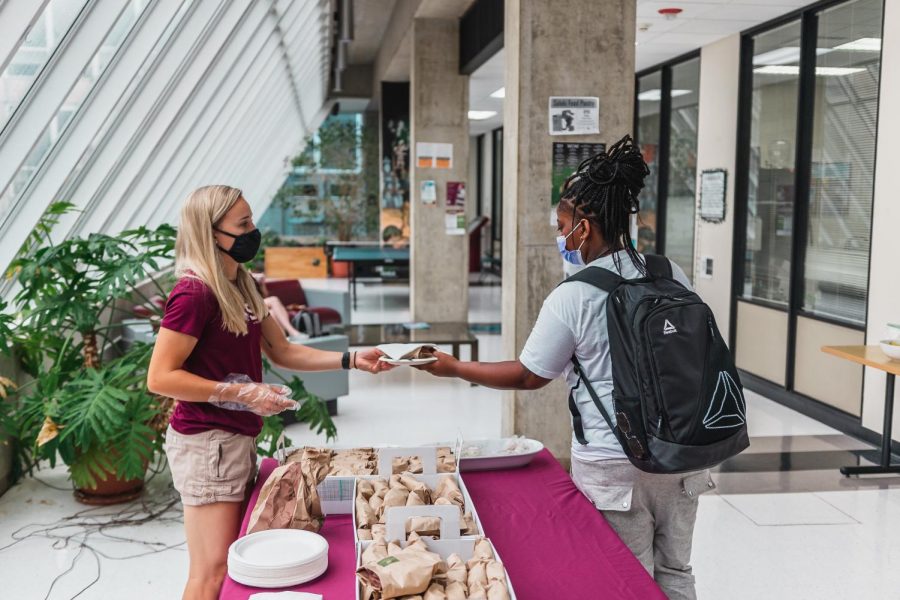 Savannah Long hands out bagels on Bagel Wednesday Aug. 18, 2021 at Faner Hall.
