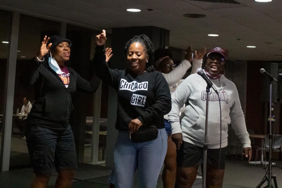 Sandra Cafey (left), Saluki mom Tameoa Johnson (middle), Saluki mom Tanya Dunlap (right) and SIU student Latanya Dunlap (back) sing “People Everyday” by Arrested Development  Sept. 24, 2021 at the karaoke event in the SIU Student Center during Family Weekend in Carbondale, Ill. “I can’t sing. It’s for entertainment purposes only.” Tanya Dunlap said.