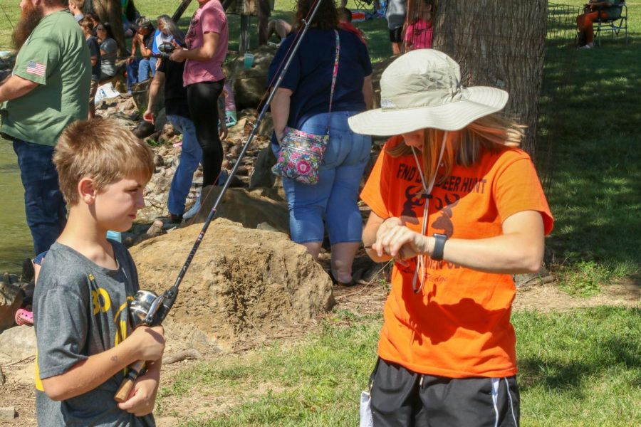 Sarah, member of the outdoor club, takes the hook out of a fish Sept. 26, 2021 at Southern Illinois Hunting and Fishing Days in Carbondale, Ill.