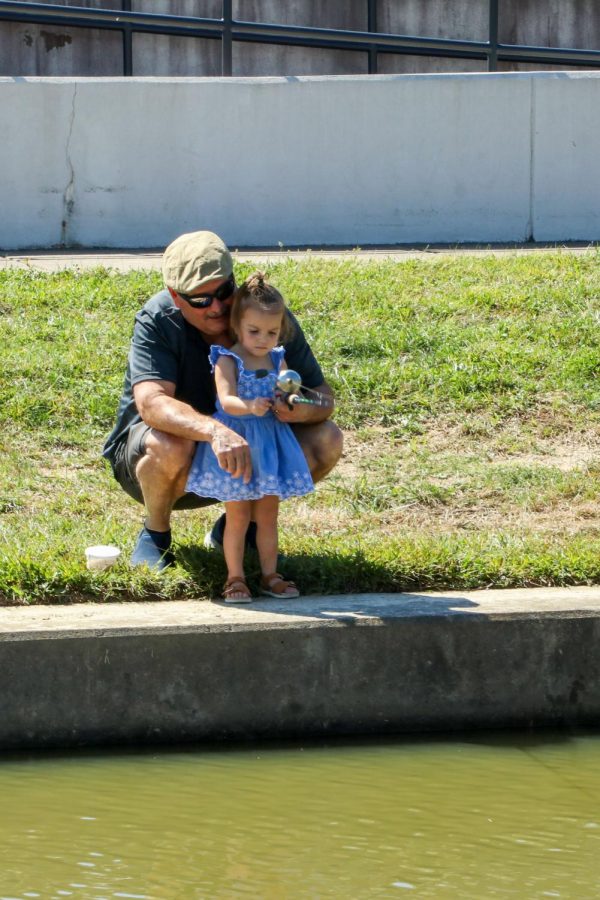 A dad teaches his daughter how to fish Sept. 26, 2021 at Southern Illinois Hunting and Fishing Days in Carbondale, Ill. I like to get kids hooked on fishing so then they wont get hooked on less desirable things that are out here, Scott Rittenhouse, head of the fair said.