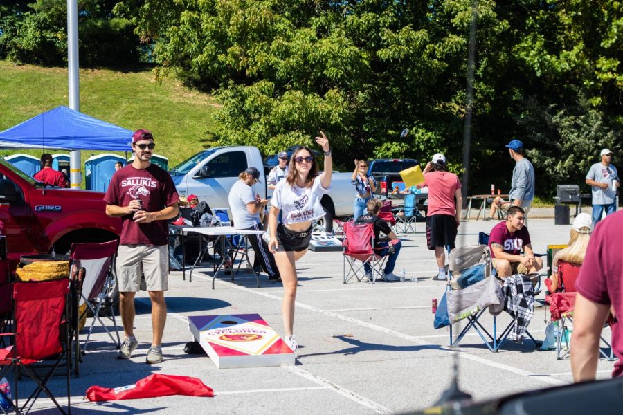 Tailgaters play corn hole before the Saluki football game Sept. 25, 2021 at the Saluki Stadium parking lot in Carbondale, Ill. 