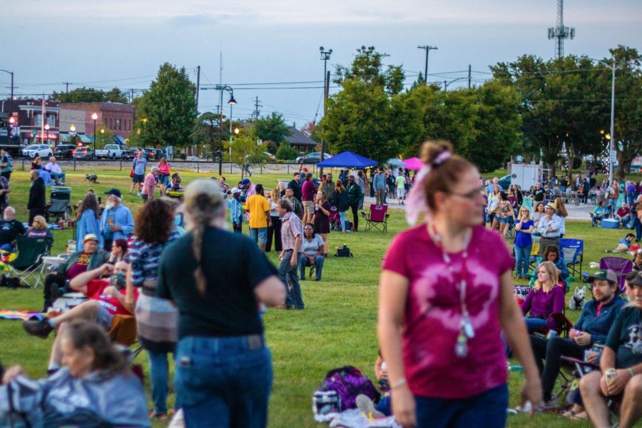 Concert-goers socialize in the field as Radio Free Honduras performs Sept. 24, 2021 at the Off the Rails concert series in Carbondale, Ill.