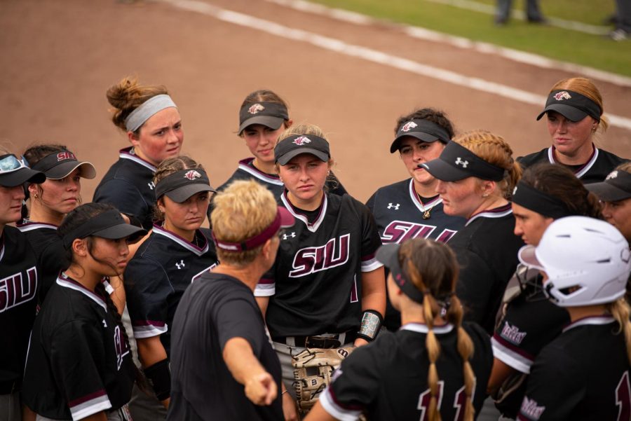 SIU softball gathers for an between inning talk from head coach Kerri Blaylock during the first game of the doubleheader vs. Three River Community College. The Salukis would win both games on Sunday, Sept. 19, 2021 at the Charlotte West Stadium in Carbondale, Illinois.  