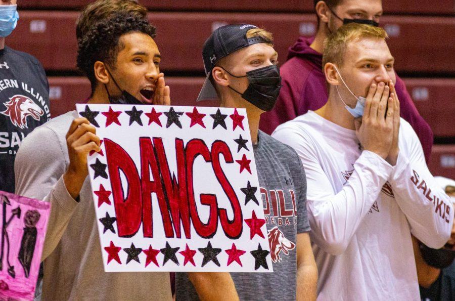 Mens+basketball+player+Dalton+Banks%2C+left%2C+holds+a+sign+and+chants+in+support+along+side+his+teammates+Markus+Domask%2C+middle%2C+and+Kyler+Filewich+%2Cright%2C+during+the+Salukis+3-0+match+win+over+the+University+of+South+Carolina+-+Upstate+on+Friday%2C+Sept.+10%2C+2021+during+the+Saluki+Invitational+at+the+Banterra+Center+at+SIU.+