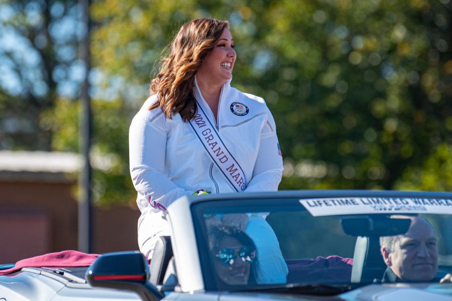 DeAnna Price, 2021 SIU Hall of Fame inductee and 2021 SIU Homecoming grand marshall, smiles towards the crowds of people lining Illinois street for the SIU homecoming parade on Saturday, Oct. 16, 2021 in Carbondale, Illinois. Price, an American hammer thrower that has completed in the 2016 and 2021 Olympics. She also set the American hammer throw record at 2021 Olympic trails with 80.31 meters. 