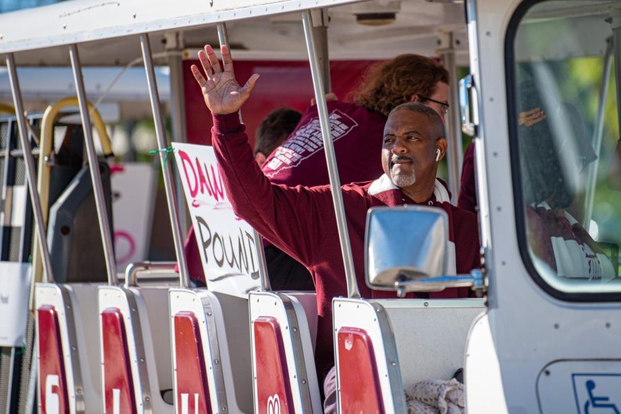 SIU chanceller, Austin Lane, waves to the crowd while riding with members of the Dawg Pound during the SIU homecoming parade on Saturday, Oct. 16, 2021 in Carbondale, Illinois. 