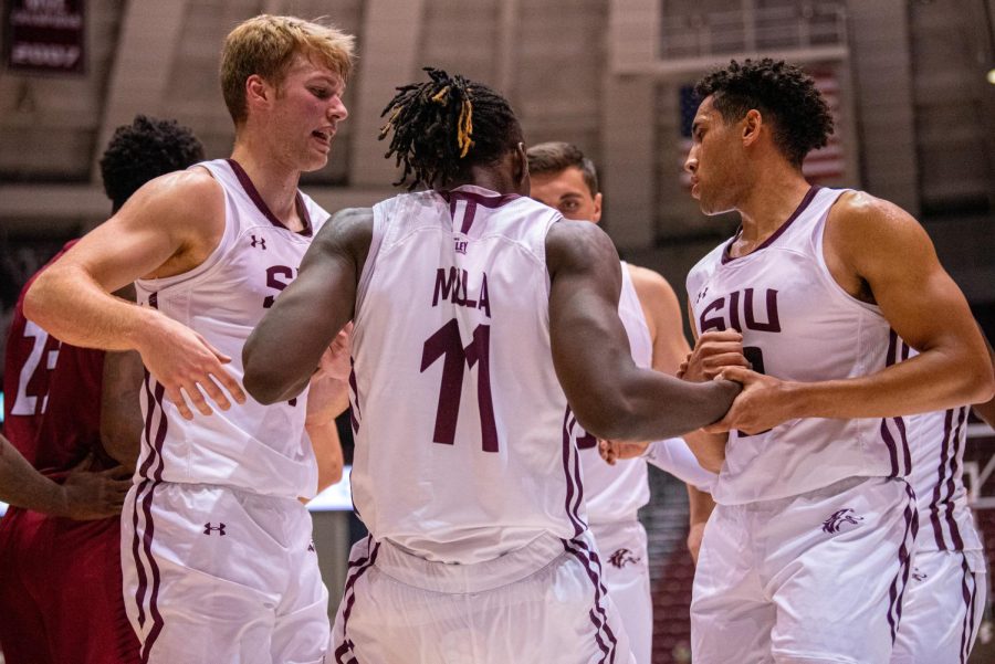 Marcus Domask, left, along with Dalton Banks helps up teammate J.D. Muila, middle, after being fouled during the Salukis 66-52 win during an exhibition game against Henderson State on Tuesday, Oct. 26, 2021 at the Banterra Center at SIU. 