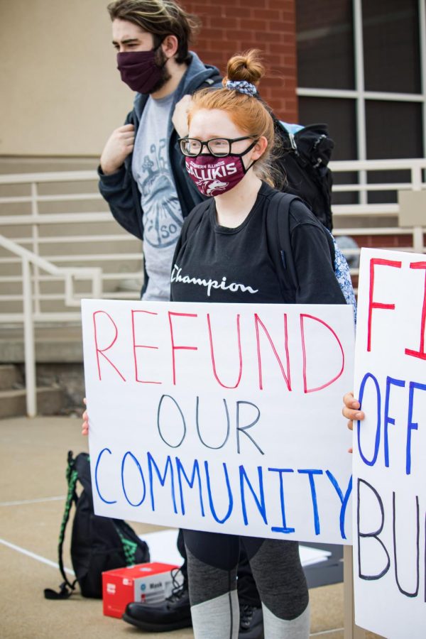 Rylee Peterson holds a sign that says, Refund Our Community, during the March for Mattie protest Oct. 13, 2021 in Carbondale, Ill. Its pretty clear that the even twas racially motivated [...] I just want to see some justice for Mattie and some action taken against Officer Burris, Peterson said. 