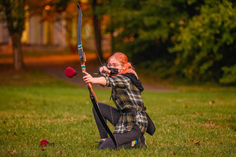 Emma Ruemmler draws back the bow and waits during a match at their practice. SIU Medieval Combat Club is a full contact combat sport that is medieval fantasy inspired where participants engage in different combat style games with a variety of boffers, also known as foam weapons on Monday, Oct. 18, 2021 northeast Morris field at SIU. 