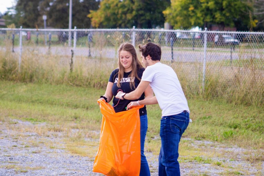 Sarah O’Connor (left), holds open a plastic trash bag for Matthew Kovich (right) to place trash into Oct. 3, 2021 in Carbondale Ill. 