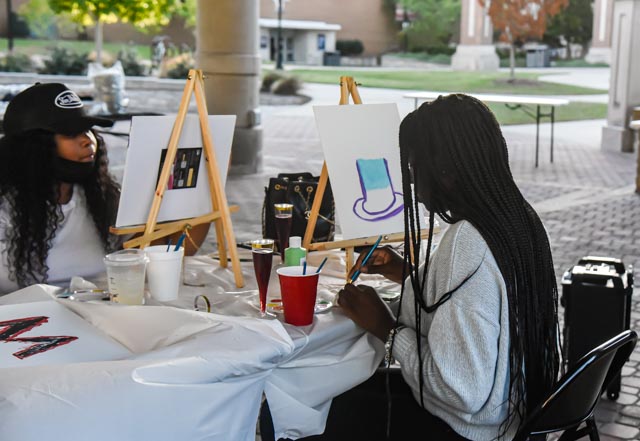 A student paints a top hat at the Paint & Sip hosted by the Black Affairs Council in the Student Services Building Pavilion at SIU Oct. 20, 2021 in Carbondale, Ill.
