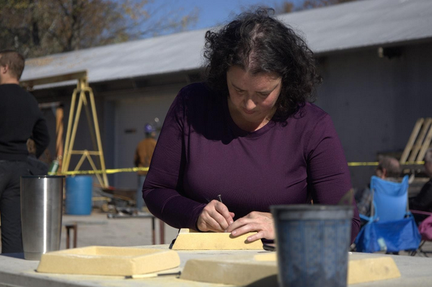 Elizabeth Taylor, an SIU student, carves a structure in the Iron Pour event on Saturday, Nov. 6,2021 at Foundry Complex in Carbondale, Illinois. “I saw some pictures on the campus about the event and thought it would be a great memory and some help for the fund-raising program. I really enjoy the event,” Taylor said.
