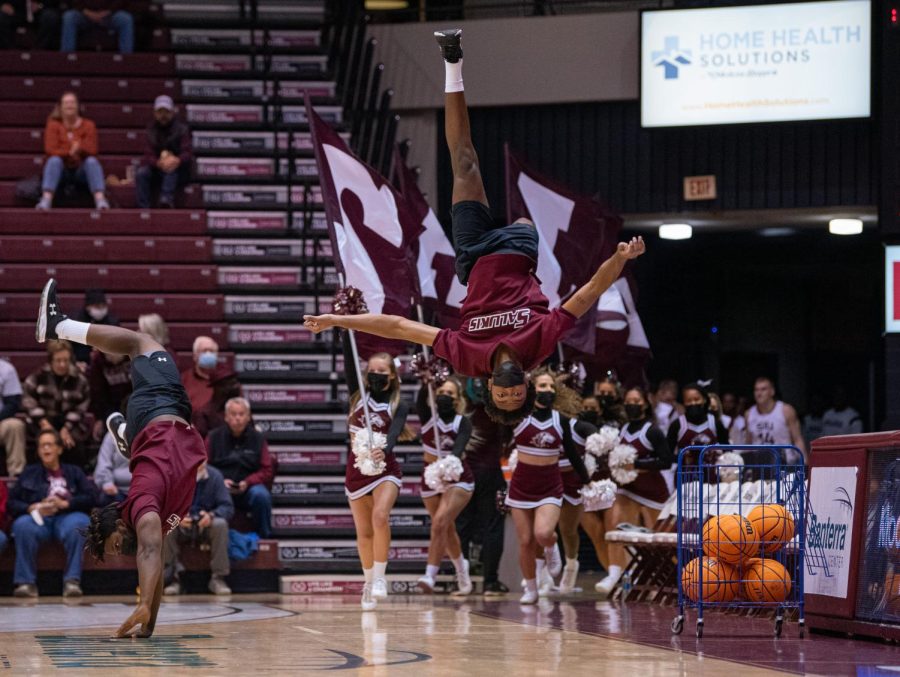 A member of the SIU cheer team does a flip as the SIU gets ready to be introduced as they take the court before the game vs. Austin Peay during the Charles Helleny Tip-Off Classic on Friday, Nov. 12, 2021 at the Banterra Center at SIU. 