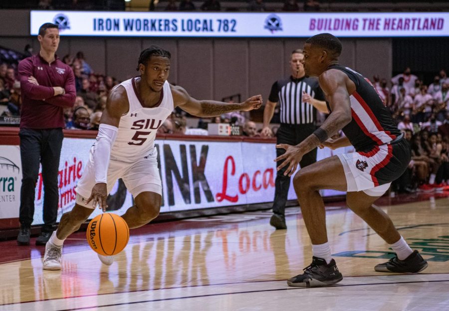 SIU guard, Lance Jones, drives the ball against an Austin Peay defender during SIUs 73-55 win over Austin Peay during the Charles Helleny Tip-Off Classic on Friday, Nov. 12, 2021 at the Banterra Center at SIU. 