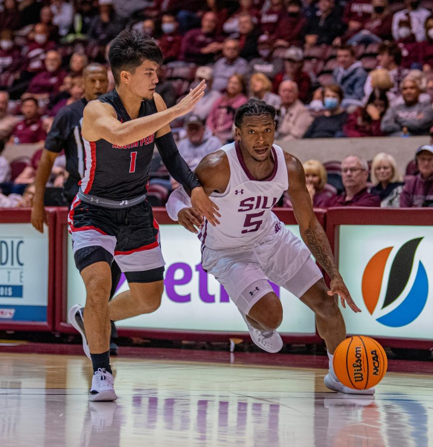 SIU guard, Lance Jones, drives the ball while being defended by Austin Peays Carlos Paez during SIUs 73-55 win over Austin Peay during the Charles Helleny Tip-Off Classic on Friday, Nov. 12, 2021 at the Banterra Center at SIU. 