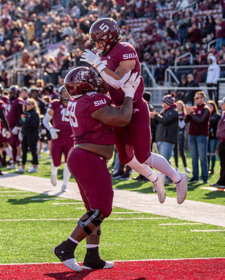 SIU offensive guard ZeVeyon Furcron, left, lifts Justin Strong after scoring a touchdown during SIUs 18-35 loss vs. Youngstown State on Saturday, Nov. 20, 2021 at Saluki Stadium at SIU.   