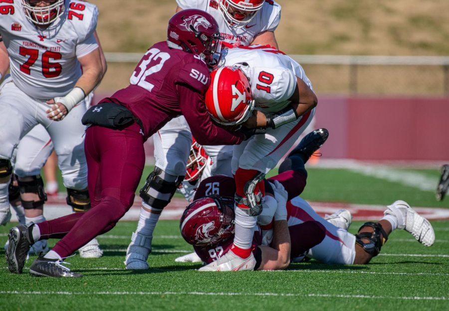 SIU safety Joe Patterson, left, assists teammate Jordan Berner sack Youngstown State quarterback, Demeatric Crenshaw, for a four yard loss during SIUs 18-35 loss vs. Youngstown State on Saturday, Nov. 20, 2021 at Saluki Stadium at SIU.   