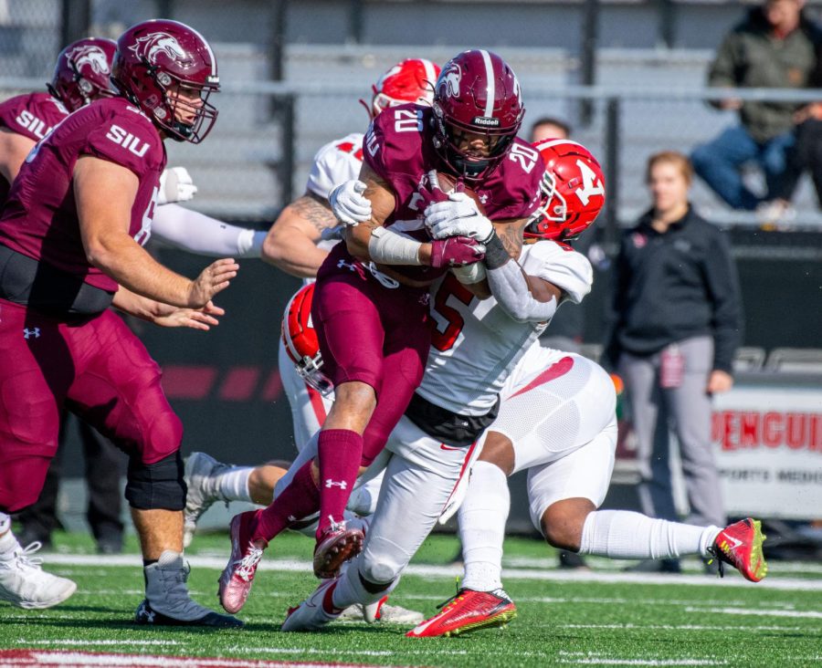 SIU running back, Donnavan Spencer, carries the ball while a Penguin defender tries to go for the tackle during SIUs 18-35 loss vs. Youngstown State on Saturday, Nov. 20, 2021 at Saluki Stadium at SIU. 