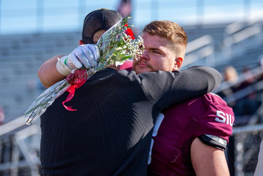 Senior tight end, Cole Steward, embraces head coach Nick Hill during the pregame ceremony on Senior Day before SIUs 18-35 loss vs. Youngstown State on Saturday, Nov. 20, 2021 at Saluki Stadium at SIU.   
