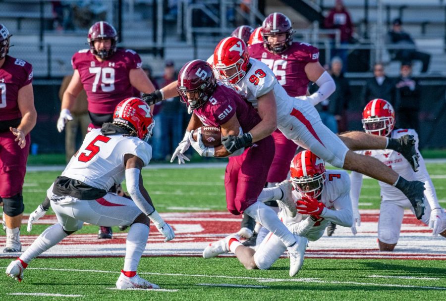 SIU running back, Justin Strong, rushes the ball as a few penguin defenders go in for the tackle during SIUs 18-35 loss vs. Youngstown State during Senior Day Saturday, Nov. 20, 2021 at Saluki Stadium at SIU.  