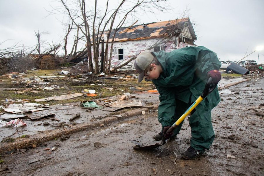 William Vinson shovels debris from the road Dec. 18, 2021 in Mayfield, Kentucky. 