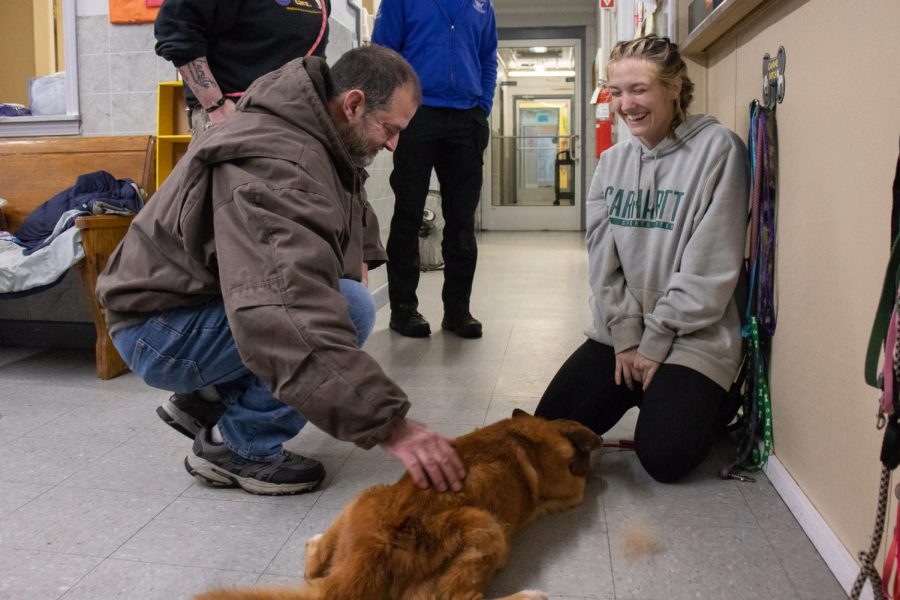 John Hoback (left) and a Mayfield-Graves County Animal Shelter volunteer pet Hobacks dog Kye after they were reunited Dec. 18, 2021 in Mayfield, Kentucky. 