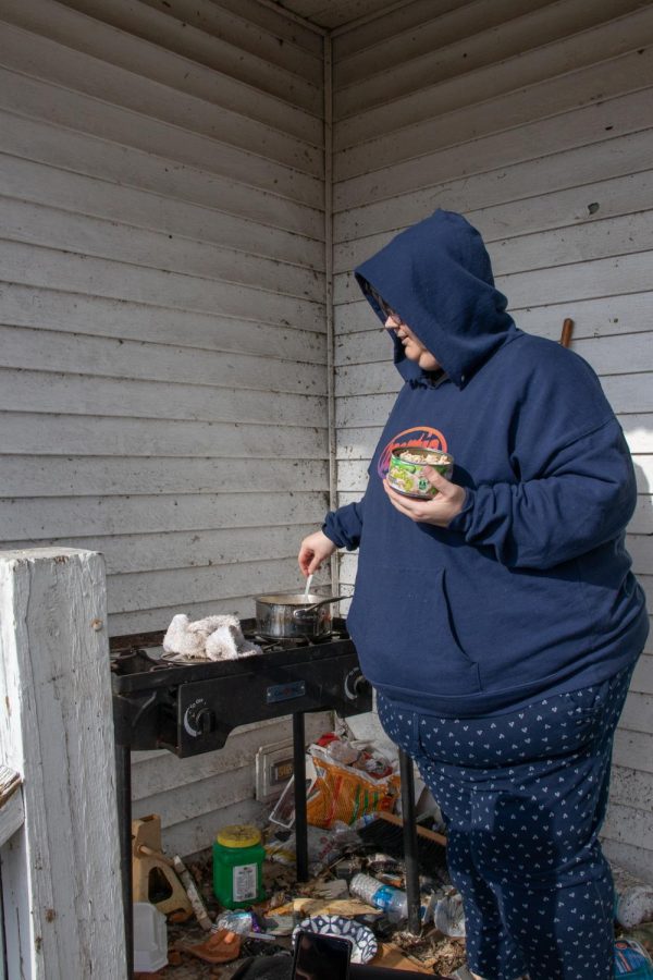 Sarah Bryan prepares lunch on her front porch Dec. 18, 2021 in Mayfield, Kentucky. She and her husband continued to recover from the storm as debris still covers her porch and lawn a week after the storm. 