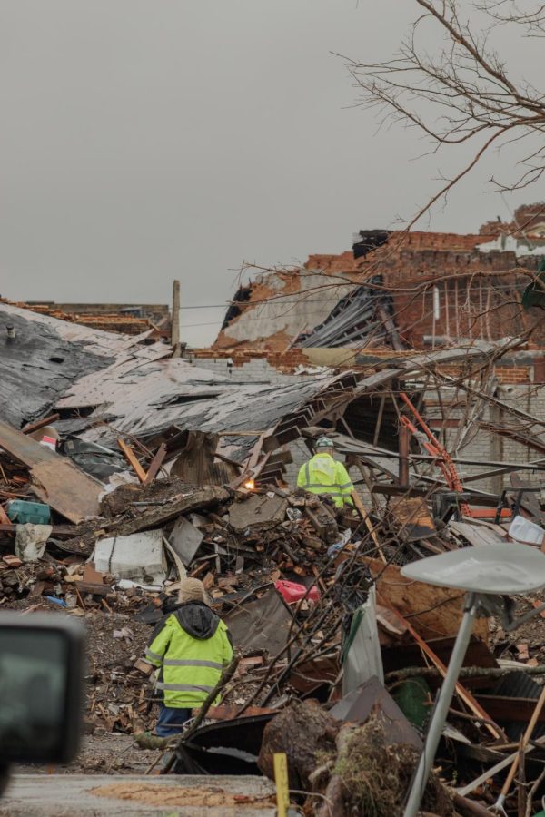Two people work among the debris of a building that was leveled in the Dec. 10 tornado Dec. 18, 2021 in Mayfield, Kentucky.