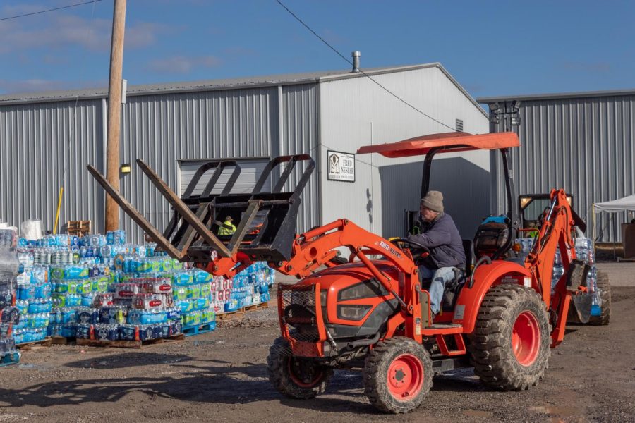 A volunteer at the Mayfield-Graves Fairgrounds moves cases of water bottles Dec. 19, 2021 in Mayfield, Kentucky.