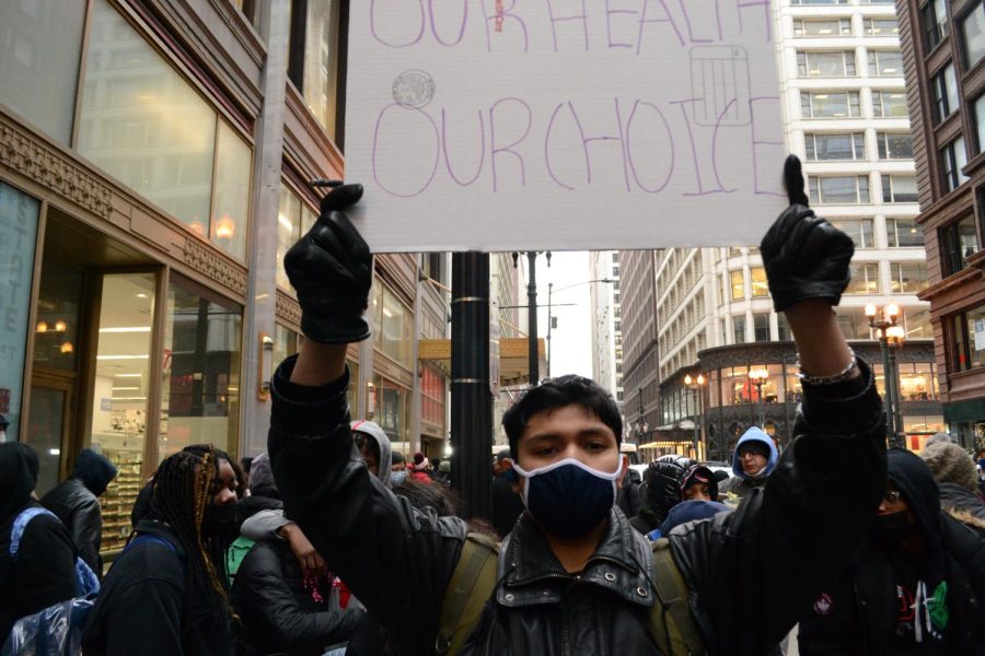A protestor holds a sign outside the Chicago Public Schools (CPS) office downtown during a rally criticizing Chicago Public Schools COVID-19 pandemic safety response on January 14, 2022 in Chicago, Ill.