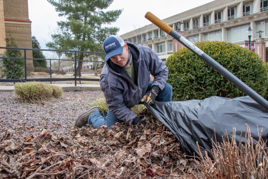 Aaron Wheeler, an SIU grounds keeper, rakes leaves into a garbage bag Jan. 24, 2022 at SIU in Carbondale, Ill. 