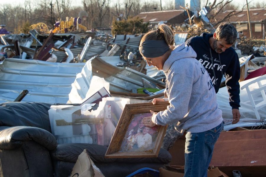 Cheryl Vincent clears off a picture of her and her son that was found in the aftermath of the Dec. 10 tornado Dec. 19, 2021 in Dawson Springs, Kentucky. 