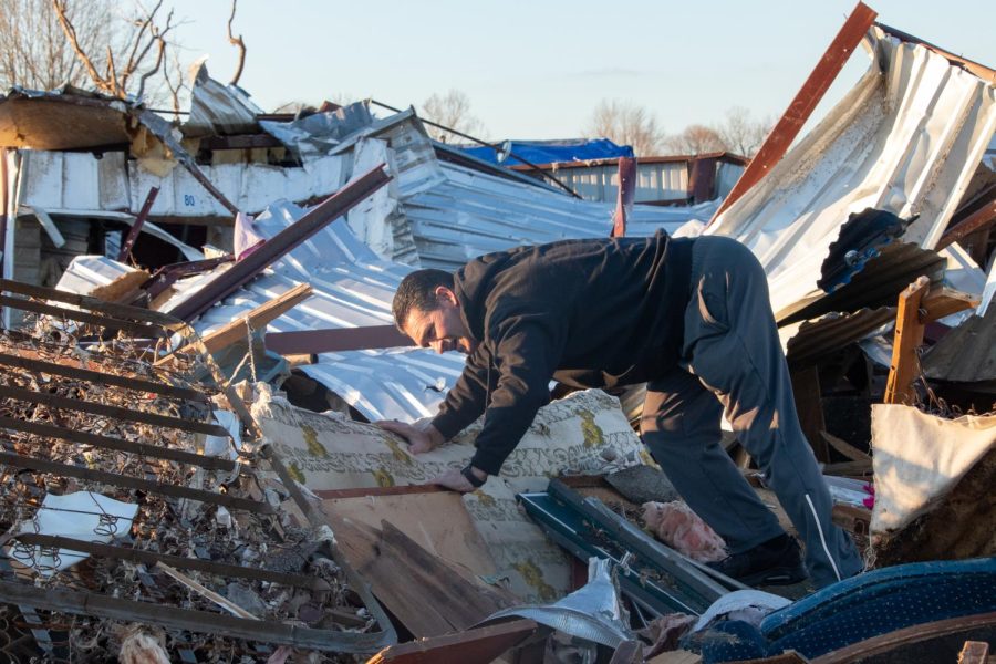 Todd Tolbert stands on a pile of rubble as he searches in a tornado-damaged storage unit for some of his mothers belongings Dec. 19, 2021 in Dawson Springs, Kentucky. 