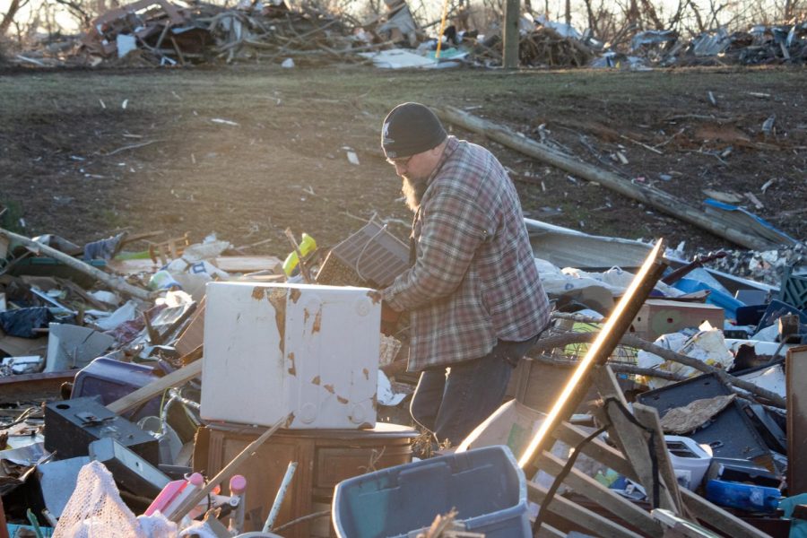 A man carries his belongings from a storage unit destroyed by the Dec. 10 tornado Dec. 19, 2021 in Dawson Springs, Kentucky. 