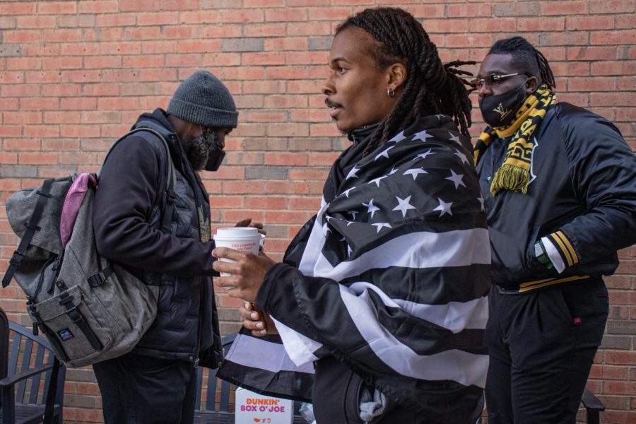 Alpha Phi Alpha Fraternity Inc. alumni, Treyonne Rawls, holds a cup of hot chocolate before the MLK Day March Jan. 17, 2022 in Carbondale, Ill. 