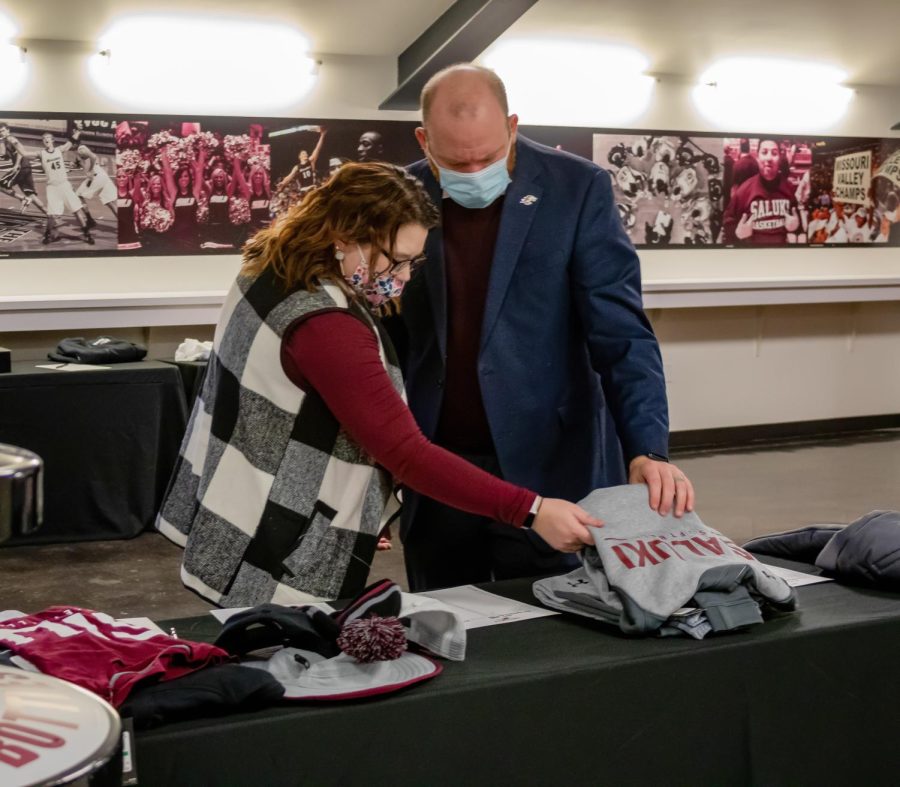 Samantha Williams (left) and Bryce Williams look through some of the items that were up for the silent auction at the SIU softball fundraising dinner Jan. 22, 2022 at the Banterra Center in Carbondale, Ill. “It’s great gear and it helps support the student athletes and at the same time you have the opportunity to buy some stuff,” Bryce Williams said. 
