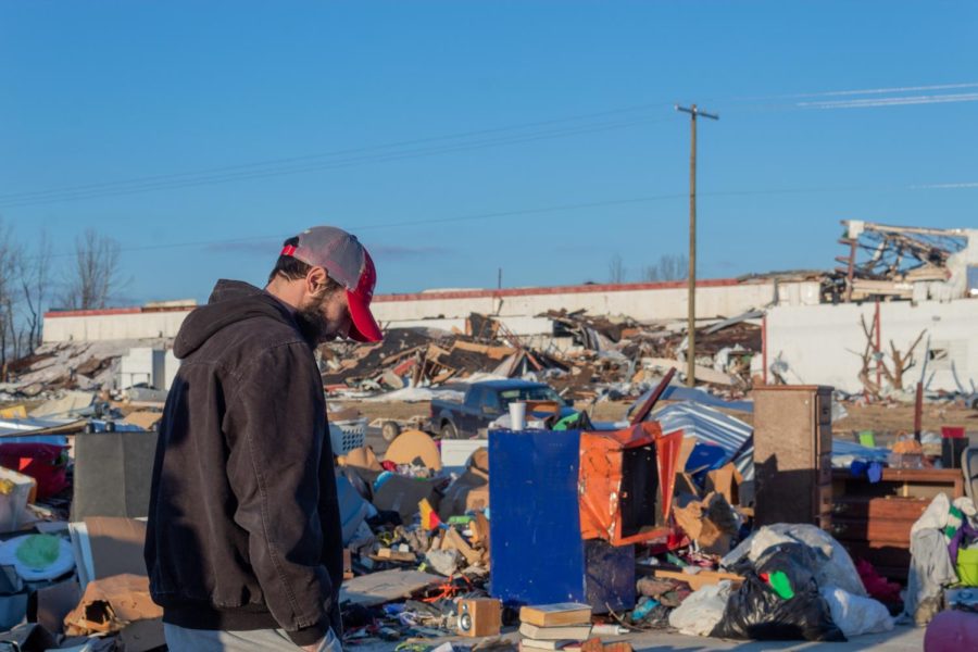 A man stands in piles of peoples belongings left strewn about after the Dec. 10 tornado Dec. 19, 2021 in Dawson Springs, Ky.