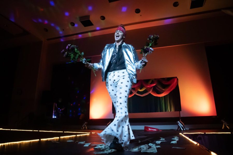 Faim Lee Jewls carries out flowers during their performance at the Spicy Seventies Disco Drag Show Feb. 19, 2022 at the SIU Student Center in Carbondale, Ill. 