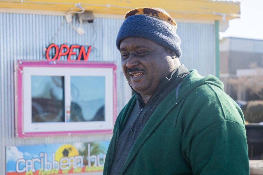 Freeman Johnson sells food at Caribbean Hut on Friday, Feb. 18, 2022, out of the Staples parking in Carbondale, Ill. Freeman has been running his food truck business since 2017. “I am originally from the Bahamas and moved to Carbondale. Caribbean food is new to this area and it’s something that is taken off. We have different seafood and Caribbean spices. Jerk chicken, jerk pork are very popular in Jamaica. Most of the people come around 11am to 2pm. People usually from 25 to 40 middle-aged people come to eat our dish. We feel really good and I am very satisfied with my job,” Johnson said.