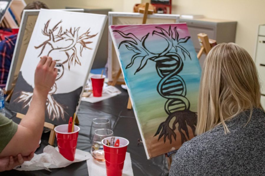Mariah Hendrickson paints a picture of a tree in the form of a DNA strand at the Project Human X paint night Feb. 19, 2022 in Carbondale, Ill. 
