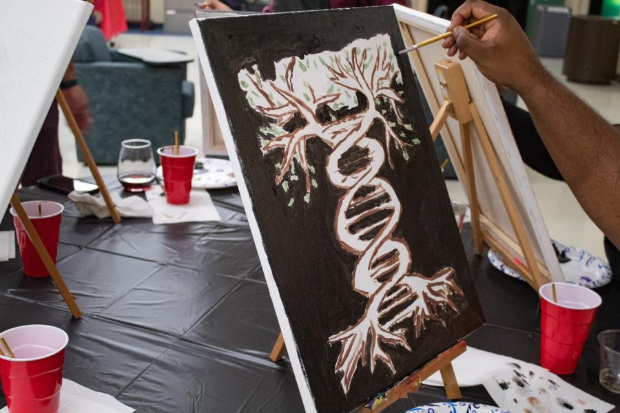 Randall Ward paints a picture of a tree in the form of a DNA strand at the Project Human X paint night Feb. 19, 2022 at the SIU Law School in Carbondale, Ill. 
