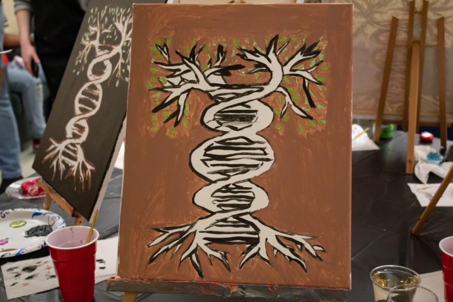 A painting of a tree in the form of a DNA strand, painted by Gloria Lewis at the Project Human X paint night, rests on a table Feb. 19, 2022 in Carbondale, Ill. 
